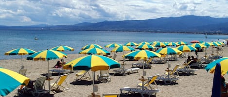 På stranden, solstolar och parasoller