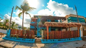 A two-story building with a blue facade and a thatched roof structure. - Pousada Casa Nui by Concavus (Ipojuca)