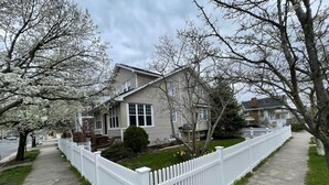 A two-story house with a white picket fence, a front yard with daffodils, and a street view. - Atlantic City Beach Retreat, Casino Fun, & 5-Min Walk to the Beach (Atlantic City)