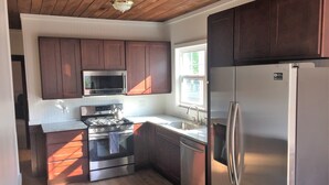 A kitchen with wooden cabinets, a stainless steel refrigerator, a microwave, a stove, and a sink. - Atlantic City Beach Retreat, Casino Fun, & 5-Min Walk to the Beach (Atlantic City)