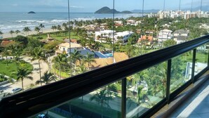 A coastal cityscape with a view of the ocean, palm trees, and residential buildings. - Beautiful fit, standing on the sand with spectacular sea views. Spotless (Bertioga)