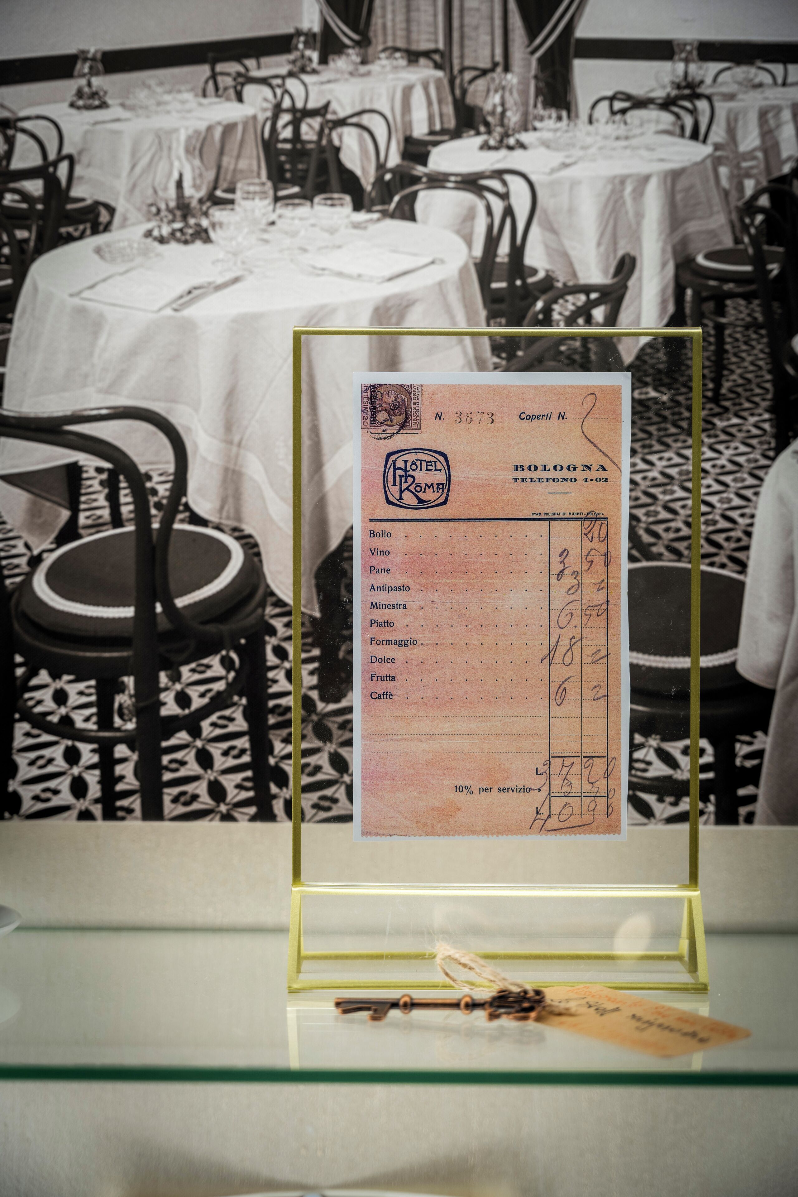 A hotel room with a dining area, a table with a menu, and a chair.