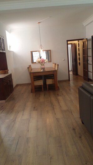 A dining area with a wooden table and chairs, a hanging light fixture, and a mirror on the wall. - Luxury, independent, 4-person apartment on the ground floor 'A Orquidea' (SANTA CATARINA CLD)