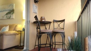 Un salon chaleureux avec un canapé beige, une petite table avec une lampe et un tableau accroché au mur.