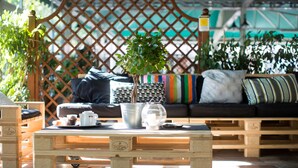 A cozy outdoor seating area with a wooden table, a potted plant, and a coffee maker. - Happy Camp in Camping Village Paestum (Eboli)