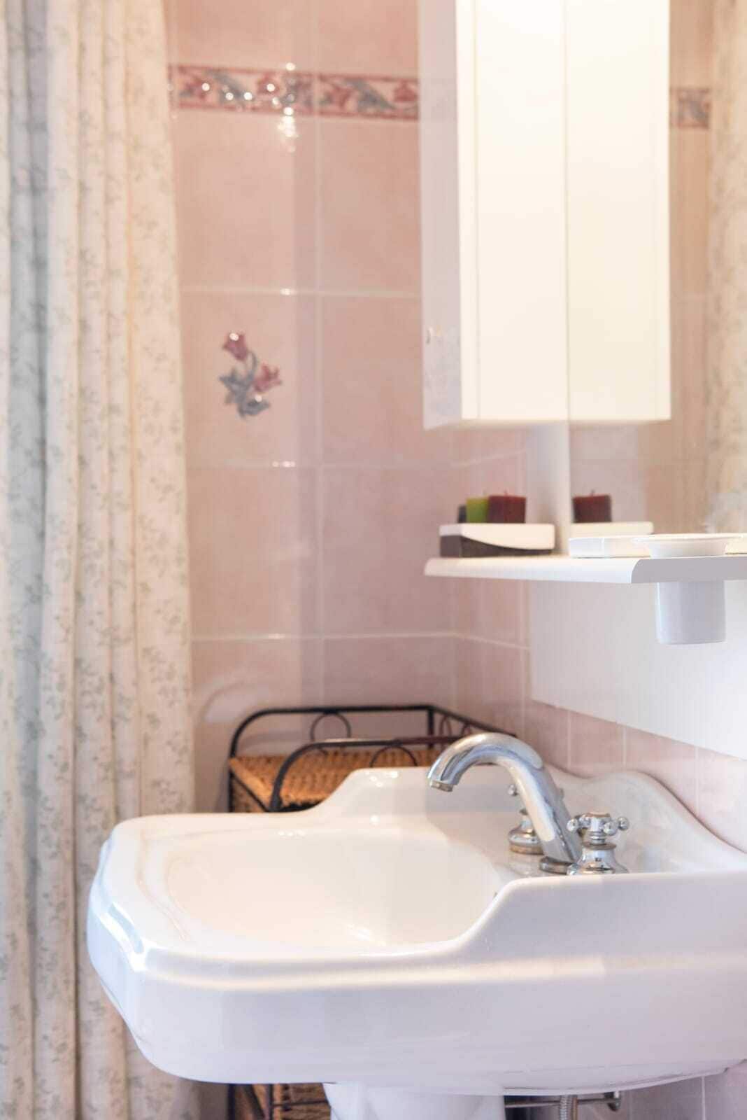 Une salle de bain avec un lavabo blanc, un miroir et un porte-serviettes.