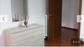 A room with a wooden dresser, a mirror, and a door. - Nice and comfortable 55 square meter apartment in the center of Avellino (Avellino)