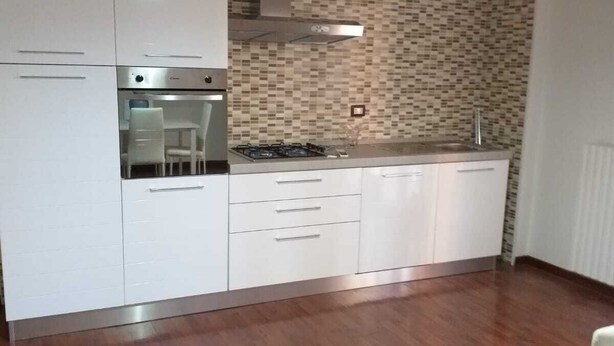 A kitchen with white cabinets, a built-in oven, a gas stove, and a patterned backsplash. - Nice and comfortable 55 square meter apartment in the center of Avellino (Avellino)