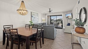 Un salon moderne comprenant un coin repas, un ventilateur de plafond, un téléviseur et un balcon avec vue.