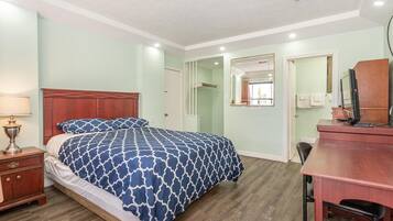 Un dormitorio con cama, escritorio, silla, lámpara y espejo.