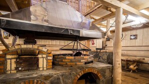 A stone oven with a brick structure, a wooden table, and a wooden ceiling. - Willa Sport (Zakopane)