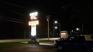 A motel sign with a neon sign and a vehicle parked nearby. - Pine Grove Motel (Sault Ste. Marie)