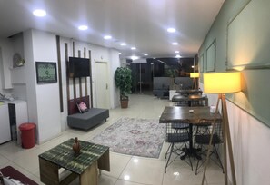 A modern living room with a sofa, a dining table, and a lamp. - Su Residence (Trabzon)
