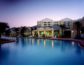 A hotel with a swimming pool, multiple buildings, and lounge chairs. - NEW in South Florida (Weston)