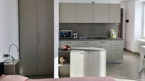 Una cocina moderna con armarios grises, un microondas y una tetera sobre la encimera.