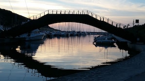 Un puente sobre una masa de agua tranquila con barcos amarrados cerca.