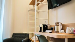 A room with a desk, two chairs, a TV mounted on the wall, and a shelving unit. - My Maison 109 (Rome)