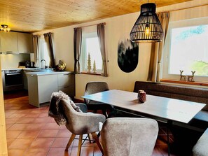 Una cocina moderna con zona de comedor, que incluye una mesa, sillas y un banco.