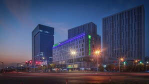 A multi-story hotel with a modern design, featuring a prominent sign for the Holiday Inn Express.