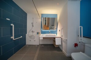A modern bathroom with blue tiles, a sink, a mirror, and a toilet. - Holiday Inn Express Shanghai Huijin by IHG (Shanghai)