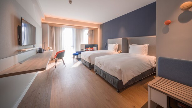 A modern hotel room with two beds, a desk, a chair, and a TV. - Holiday Inn Express Shanghai Huijin by IHG (Shanghai)