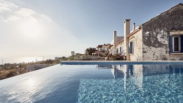 Een buitenzwembad en ligstoelen