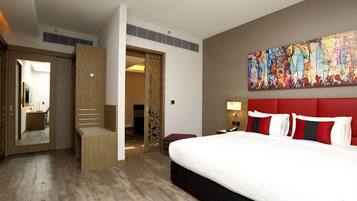 Una habitación de hotel con cama, un cuadro grande, un armario y un baño.