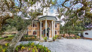 A large, two-story building with a symmetrical facade, columns, and a central entrance.