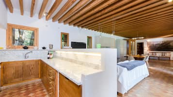 Una cocina moderna con armarios de madera, encimera de mármol y un amplio ventanal.