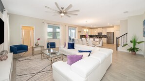 A modern living room with a white sofa, a glass coffee table, and a ceiling fan. - (JD8821) Champions Gate 6/6, Private Pool with Spa & Free Waterpark (Kissimmee)