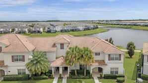 A residential area with houses, a lake, and a clear sky.