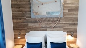 Een kamer met een bed, twee nachtkastjes, een hangend net en houten wandpanelen.