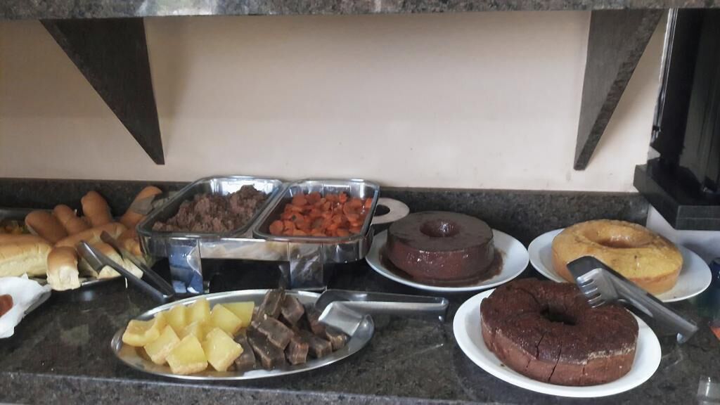 A buffet with various food items including cakes, pastries, and fruits.