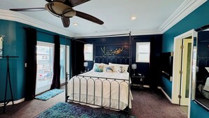 A bedroom with a four-poster bed, a ceiling fan, and a view of the street through a large window. - Large 4 bedroom, steps from the beach with rooftop patio and jacuzzi. Sleeps 10 (Long Beach)