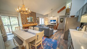 A spacious living area with a dining table, sofa, and a large TV. - Flying Dutchman 1117 (Keystone)