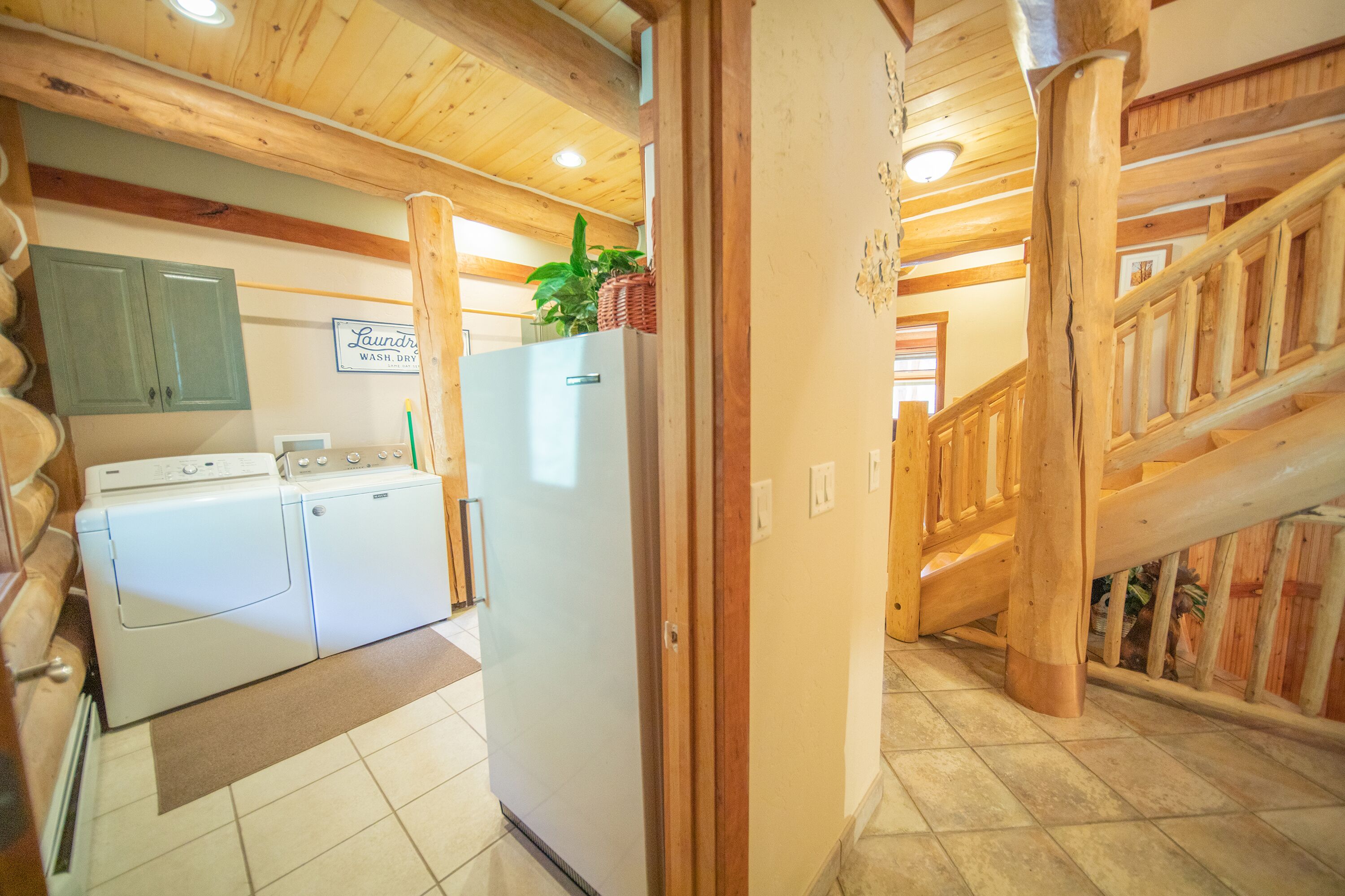 A laundry area with a washing machine, dryer, and refrigerator.