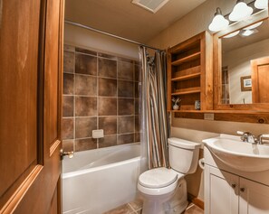 A bathroom with a bathtub, toilet, and sink.