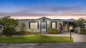 A single-story house with a front porch, a garage, and a well-maintained lawn. - 25%Off/Disney 9 mi/Heated Pool/PlayYard/Gym/Courts (Davenport)
