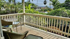 A covered outdoor area with wicker furniture and a white railing. - UPPER UNIT  -1500 sq/ ft - 30 + days ! (Kailua-Kona)