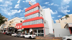 A modern hotel with a red and white facade, multiple floors, and a visible entrance. - Hotel Conda (Chapecó)