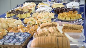 A buffet table with various baked goods and desserts.