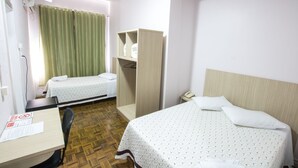 A hotel room with two single beds, a desk with a chair, a wardrobe, and a television mounted on the wall. - Hotel Conda (Chapecó)
