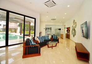 A spacious lobby with a pool view, modern furniture, and a glass wall. - Mayakoba by Select (Playa del Carmen)
