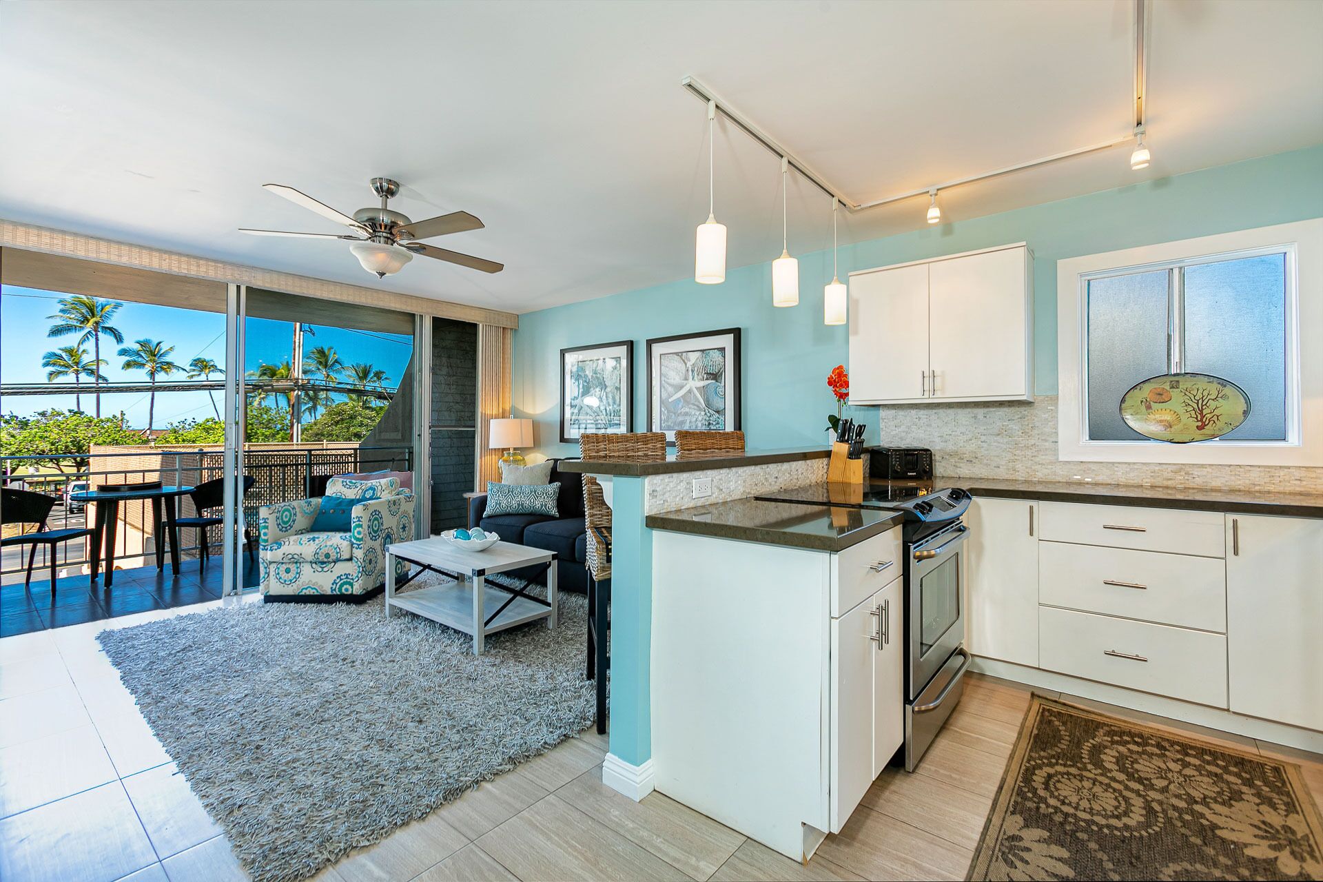 A modern kitchen with a central island, white cabinets, and a view of the outdoors.