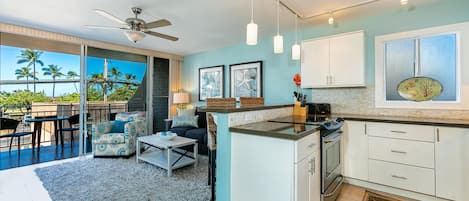 A modern kitchen with a central island, white cabinets, and a view of the outdoors.