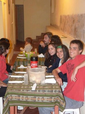 Un comedor con mesas cubiertas de manteles estampados, una botella de Coca-Cola y saleros y pimenteros.