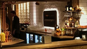 A bar area with a counter, shelves of bottles, glasses, and a display of fruits and vegetables. - Hemavans Högfjällshotell (Hemavan)