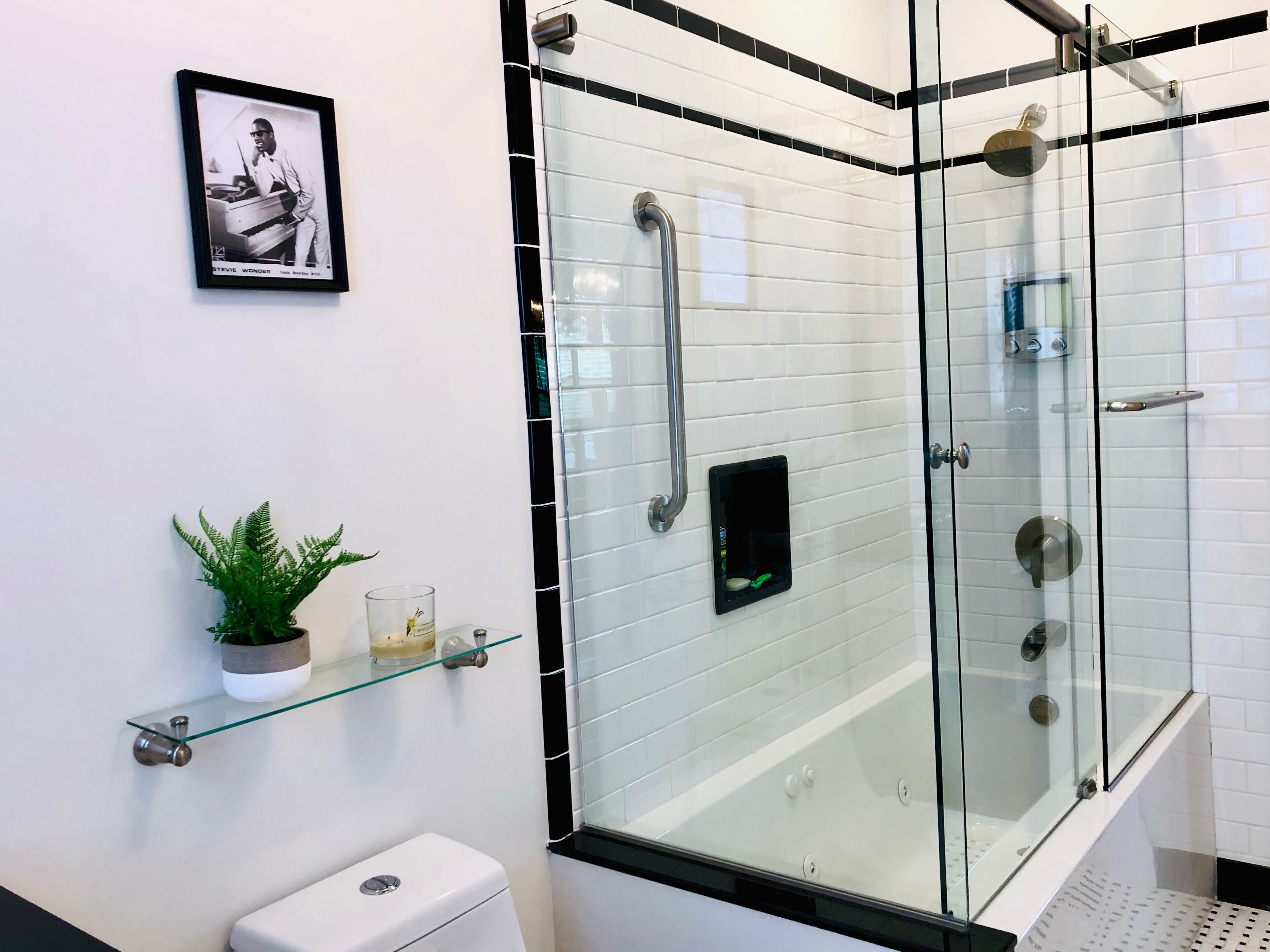 Een bad/douchecombinatie, een bubbelbad, een haardroger, handdoeken