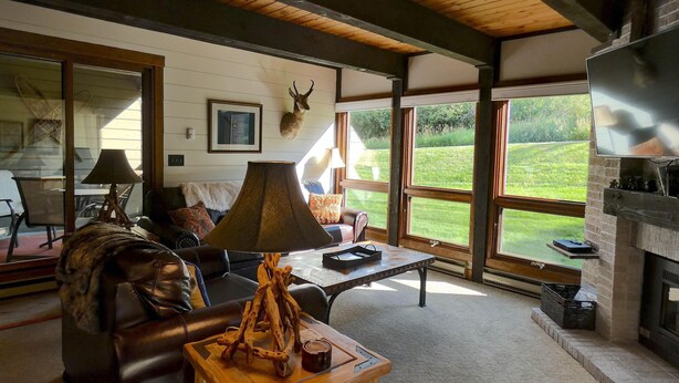 Una sala de estar acogedora con chimenea, sofá de cuero y una mesa de centro con un adorno decorativo.