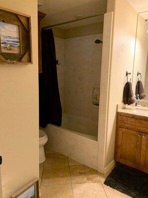 Ein Badezimmer mit Dusche, Toilette und Waschtisch.